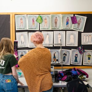 Students in CSU Theatre look at costume sketches in the costume shop on the CSU campus